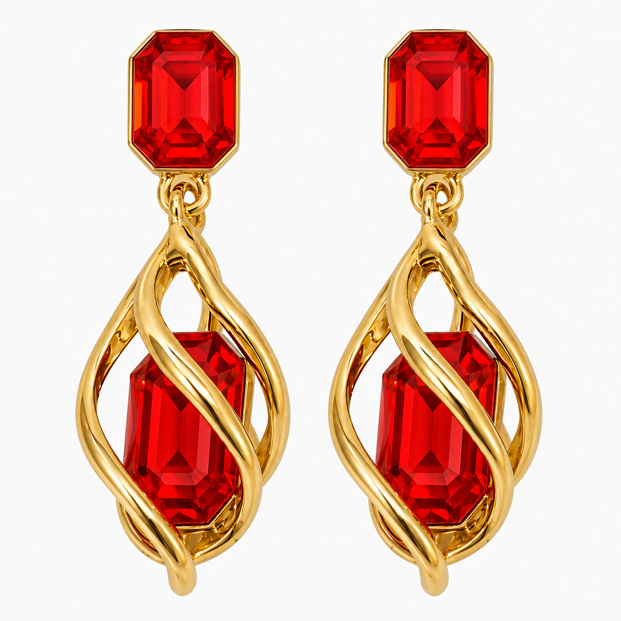 A pair of gold drop earrings featuring faceted red gemstones, with a smaller rectangular red stone at the top and a larger teardrop-shaped red stone wrapped in twisted gold metal below, set against a plain white background.