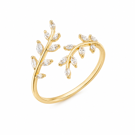 A gold open ring designed as a leafy branch, adorned with marquise-cut clear gemstones, shown on a plain white background.